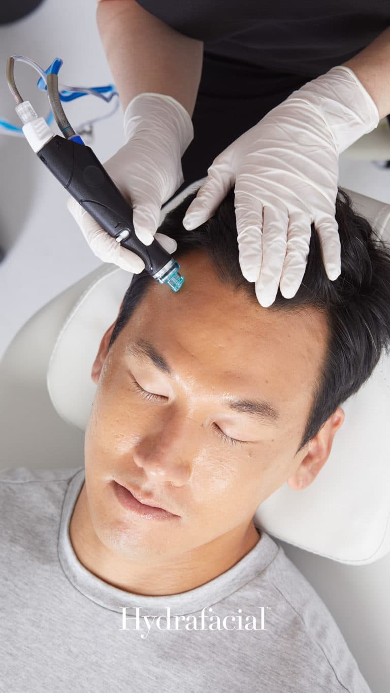 A person enjoying a refreshing Hydrafacial treatment on their forehead.